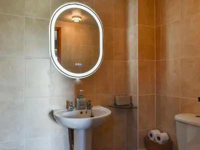 a bathroom with a sink and a mirror at Carriage House in Mawgan Porth