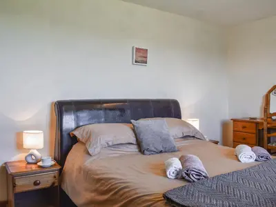 a bedroom with a bed with towels on it at Carriage House in Mawgan Porth
