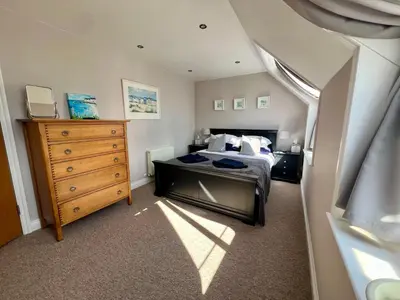 a bedroom with a bed and a wooden dresser at Pufflings, Padstow Coastal Cottage, Free Private Parking in Padstow