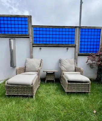 two wicker chairs and a table in the grass at Pufflings, Padstow Coastal Cottage, Free Private Parking in Padstow