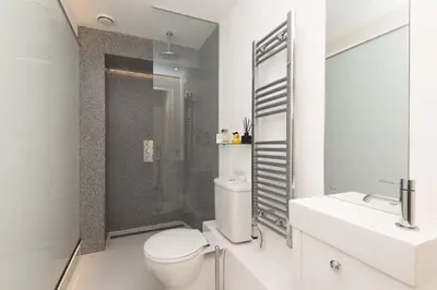 a white bathroom with a toilet and a shower at The Vicarage - Grand Country House, Walking Distance to Padstow and with Pub Across the Road in Wadebridge