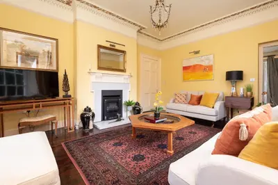 a living room with a couch and a tv at The Vicarage - Grand Country House, Walking Distance to Padstow and with Pub Across the Road in Wadebridge