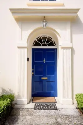 a blue front door of a white house with an arch at The Vicarage - Grand Country House, Walking Distance to Padstow and with Pub Across the Road in Wadebridge