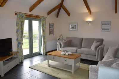 a living room with a couch and a tv at Ash Cottage, 3 bed large cottage in Tregoney