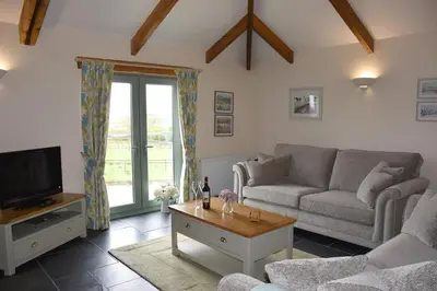 a living room with a couch and a tv at Ash Cottage, 3 bed large cottage in Tregoney