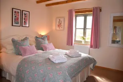 a bedroom with a bed with towels on it at Ash Cottage, 3 bed large cottage in Tregoney