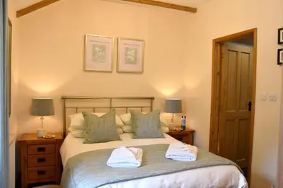 a bedroom with a bed with two towels on it at Beech cottage is a beautiful 1 bed cottage in Saint Ewe