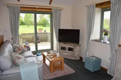 a living room with a couch and a television at Beech cottage is a beautiful 1 bed cottage in Saint Ewe