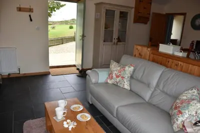 a living room with a couch and a coffee table at Beech cottage is a beautiful 1 bed cottage in Saint Ewe
