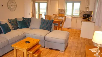 a living room with a couch and a table at Elm Cottage Delightful 2 bed accessible holiday cottage in Tregoney