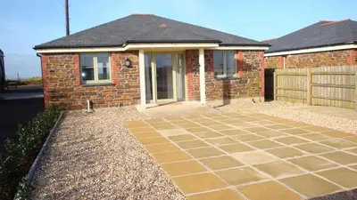 a brick house with a driveway in front of it at Elm Cottage Delightful 2 bed accessible holiday cottage in Tregoney