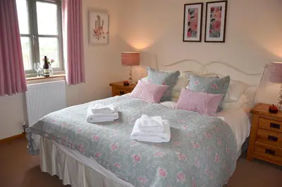a bedroom with a bed with towels on it at Hawthorn Cottage Luxury stone Built Cottage in Tregoney