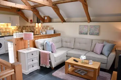 a living room with a couch and a table at Oak Cottage in Tregoney