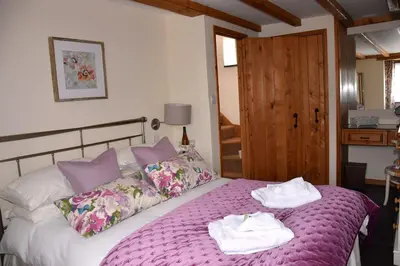 a bedroom with a bed with towels on it at Oak Cottage in Tregoney