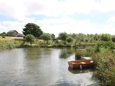 a small boat sitting in the middle of a river at Oak Cottage in Tregoney