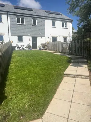 a house with a fence and a grass yard at Meadowvine in Penryn