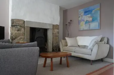 a living room with two couches and a fireplace at Dunlin Cottage in Penryn