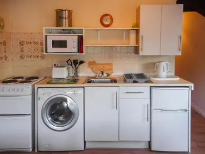 a kitchen with a washing machine and a sink at The Shippen - Uk49830 in Callington
