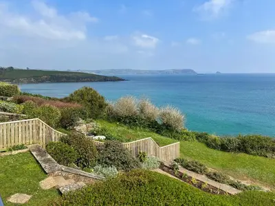 a garden with a view of the ocean at Coastguards in Porthscatho