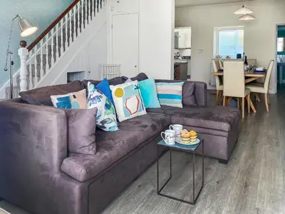 a living room with a brown couch and a table at Coastguards in Porthscatho