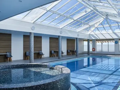 a large swimming pool with a glass ceiling at Little Palms in Bude