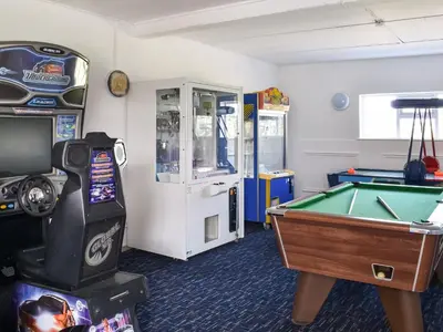 a room with a pool table and a video game at Little Palms in Bude