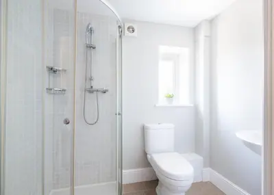 a white bathroom with a toilet and a shower at 1 The Terrace in Padstow