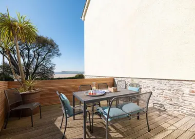 a patio with a table and chairs on a deck at 1 The Terrace in Padstow