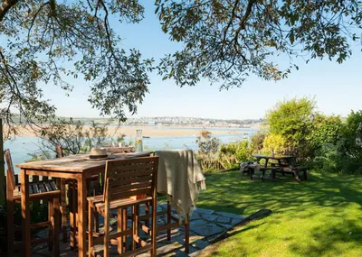 a table and chairs in a yard with a view of the water at 1 The Terrace in Padstow