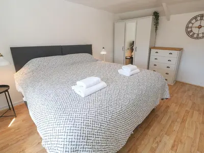a bedroom with a bed with two towels on it at Candle Croft in Redruth