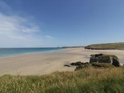 a beach with some rocks and the ocean at Candle Croft in Redruth