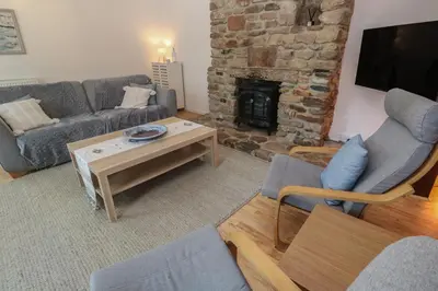 a living room with a couch and a fireplace at Candle Croft in Redruth