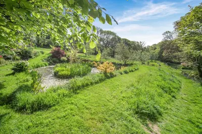 a path through a garden with a stream at 2 Bed in Advent oc-o31790 in Lanteglos