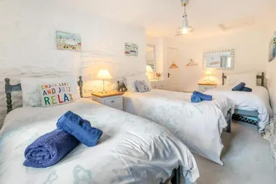 two beds in a bedroom with blue towels on them at 2 Bed in Advent oc-o31790 in Lanteglos