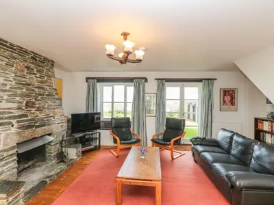 a living room with a couch and a fireplace at Tremorla in Boscastle