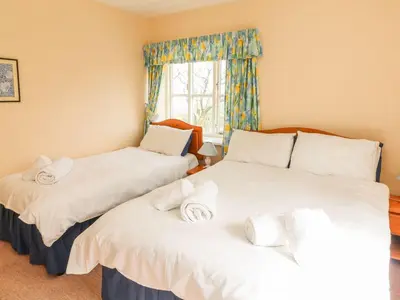 two twin beds in a room with a window at Tremorla in Boscastle