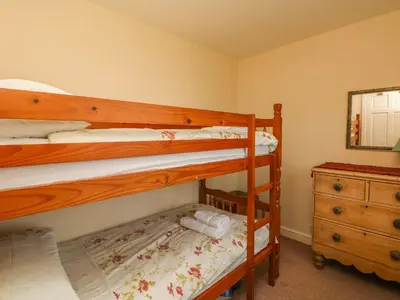 a bedroom with two bunk beds and a dresser at Tremorla in Boscastle