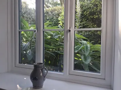 a vase sitting on a table in front of a window at Tremorla in Boscastle