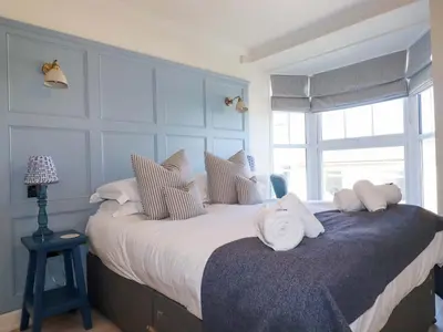 a bedroom with a large bed with white pillows at Beach View House in Newquay