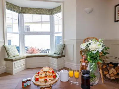 a table with a plate of food and a window at Beach View House in Newquay