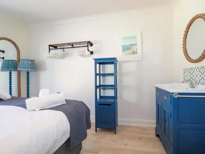 a bedroom with a blue cabinet and a sink at Beach View House in Newquay