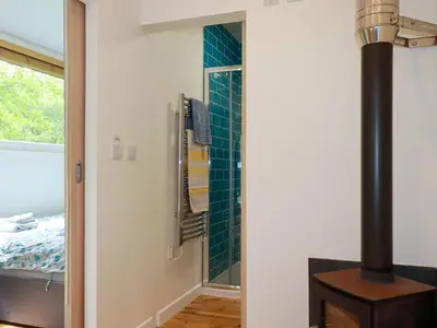 a bathroom with a fireplace and a green tiled wall at Foxglove in Bodmin