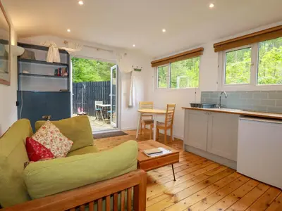 a living room with a couch and a kitchen at Foxglove in Bodmin