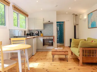 a kitchen and living room with a couch and a table at Foxglove in Bodmin