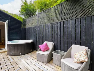 a patio with two chairs and a bath tub at Foxglove in Bodmin