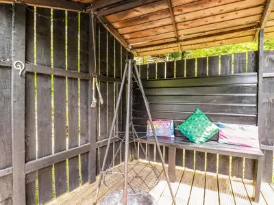 a porch with a bench with two pillows on it at Bluebell in Bodmin