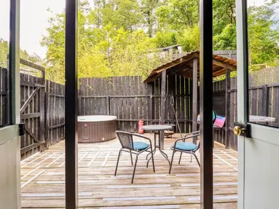 a patio with chairs and a table on a deck at Bluebell in Bodmin