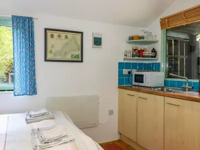 a kitchen with a bed and a sink and a microwave at Bluebell in Bodmin