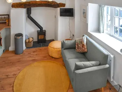a living room with a couch and a wood stove at Roseland Retreat - Uk49838 in Truro