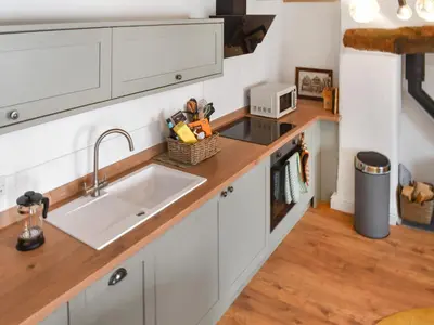 a kitchen with white cabinets and a sink at Roseland Retreat - Uk49838 in Truro